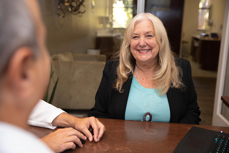 a doctor talking to a patient while she smiles to him