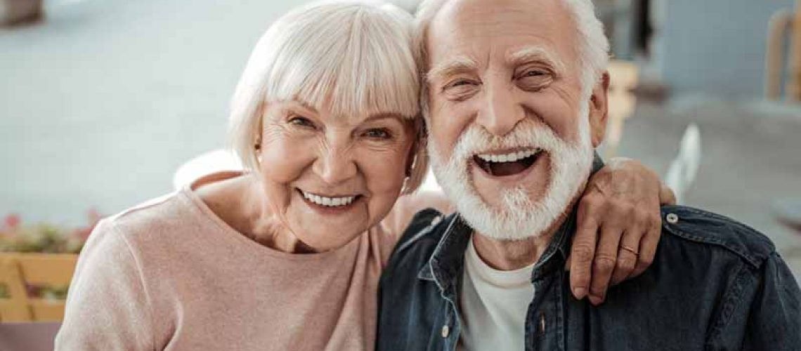 a couple smiling with their new dental implants